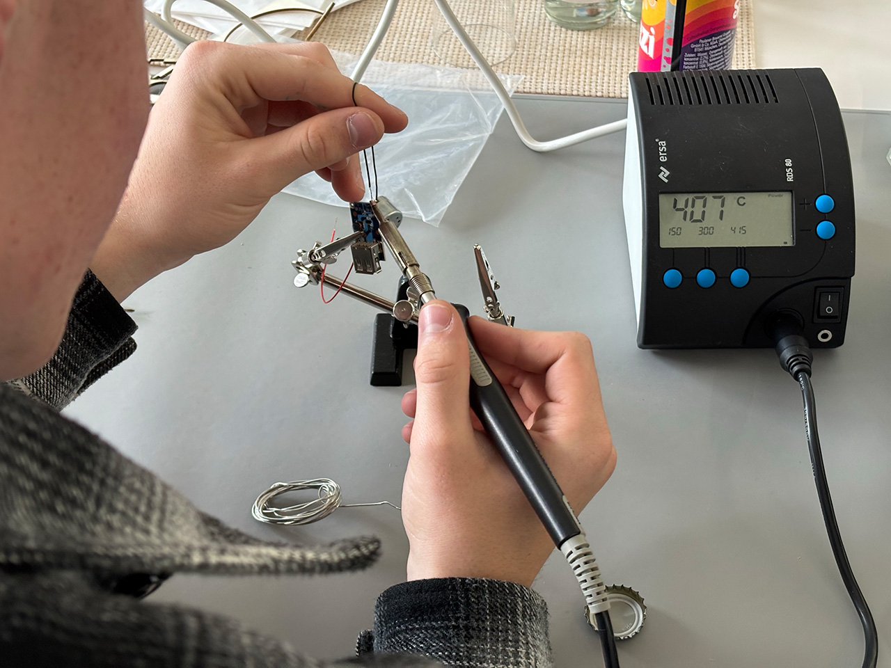 Eine Person lötet Kabel an eine Platine für einen Mini-Generator