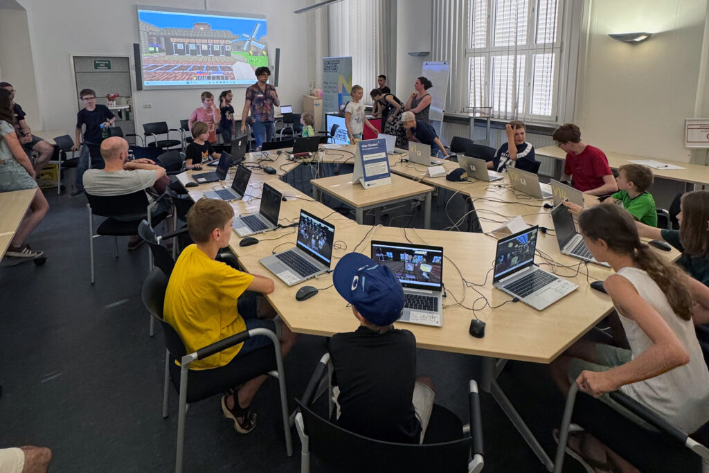 Schülerinnen und Schüler arbeiten an Laptops an der nachhaltigen Stadt Newtopia